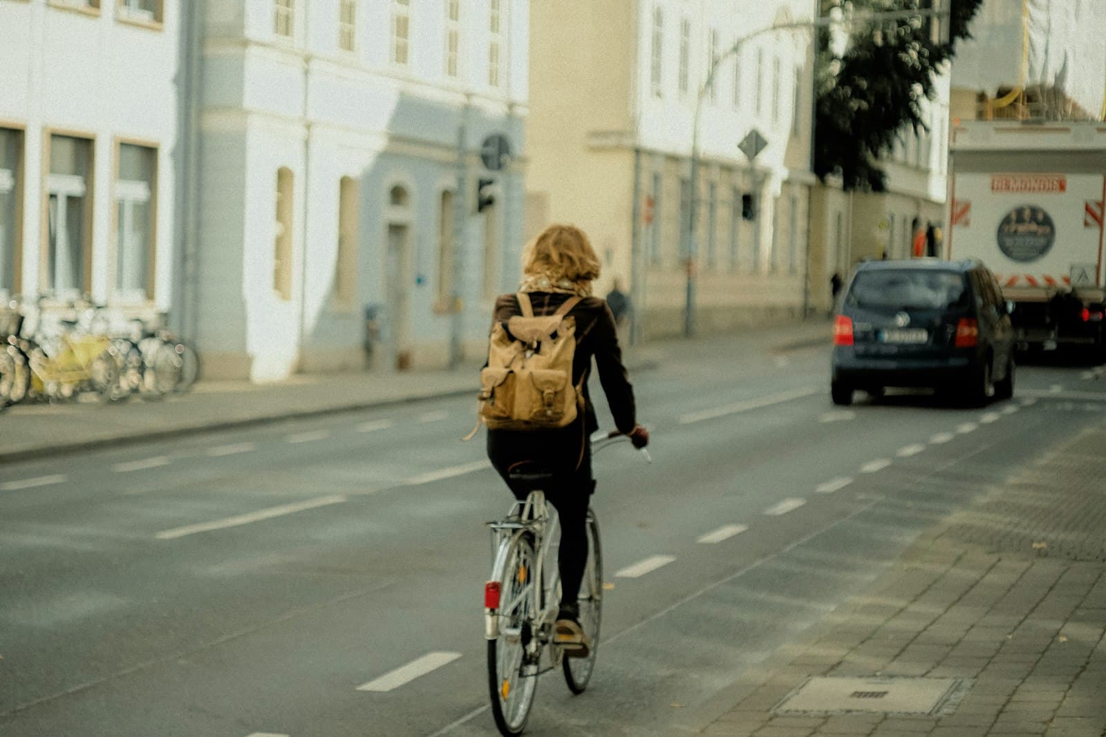 Eine Frau fährt mit dem Fahrrad über eine Straße in der Stadt