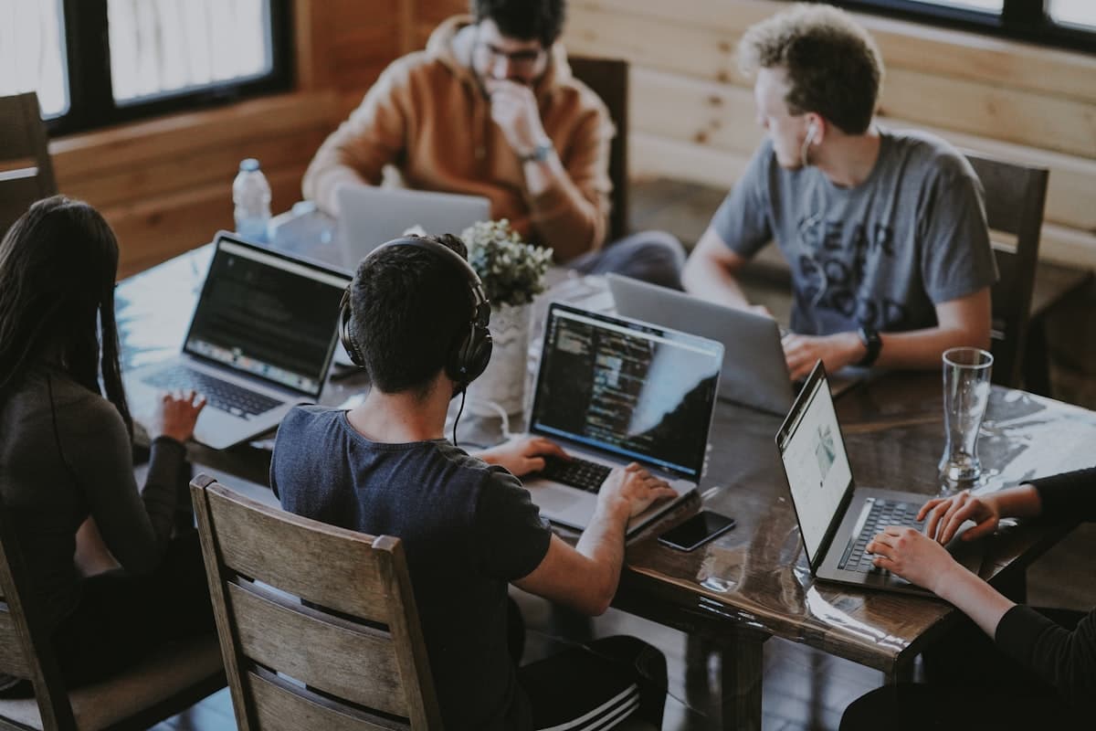 Ein junges Team arbeitet gemeinsam an Laptops