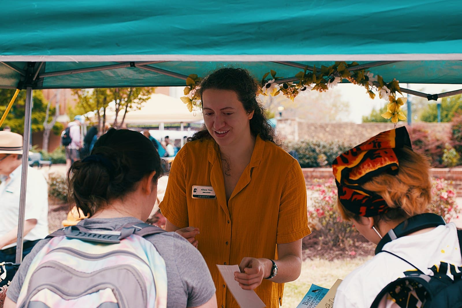 Ehrenamtliche beraten Besucherinnen an einem Infostand