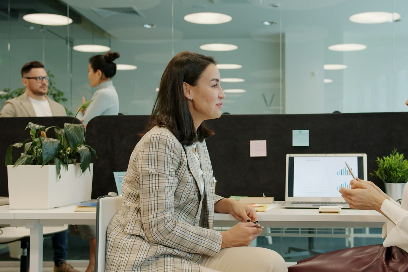Zwei Frauen im Gespräch an einem Schreibtisch in einem Büro